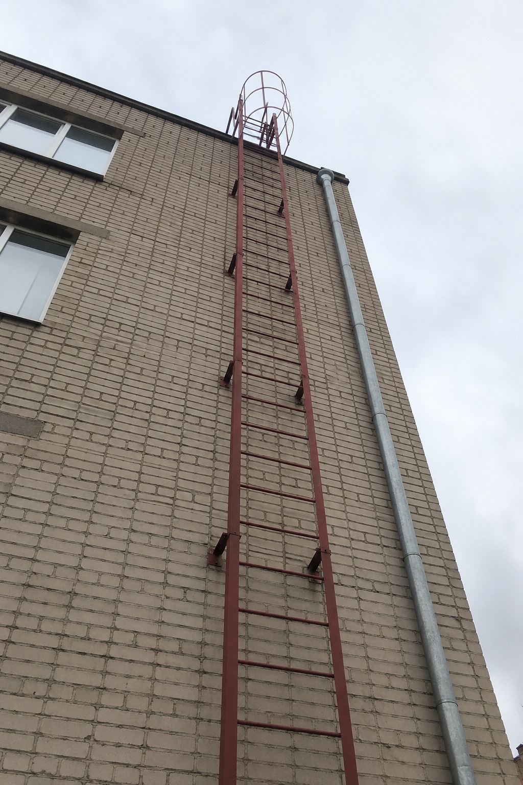 зовнішня пожежна металева драбина на фасаді будівлі